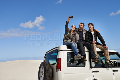 Buy stock photo Friends, car and selfie in desert  with smartphone with smile for adventure, holiday and road trip to travel. People, happy excited in sand dunes for vacation or break with bonding for memory