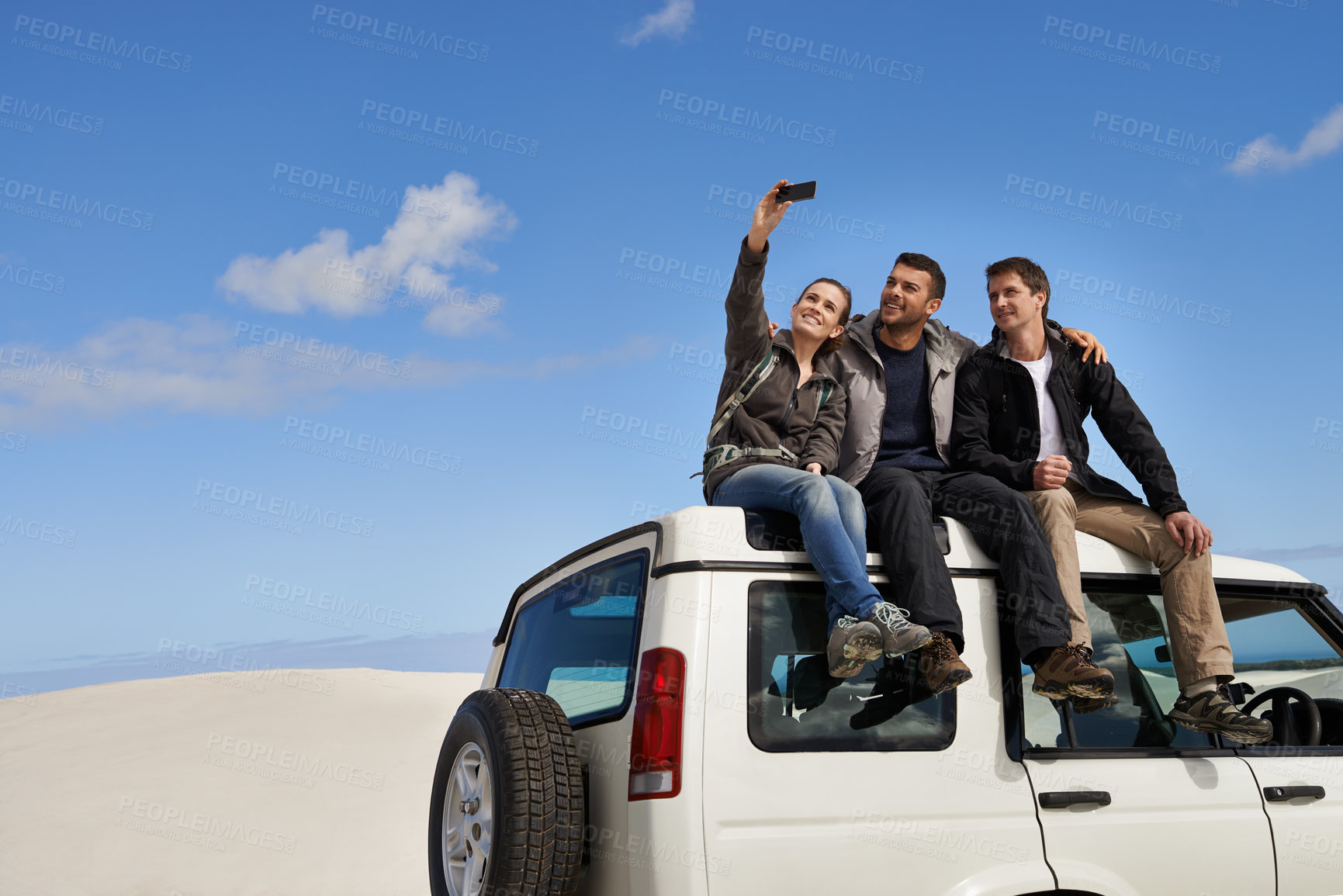 Buy stock photo Friends, car and selfie in desert  with smartphone with smile for adventure, holiday and road trip to travel. People, happy excited in sand dunes for vacation or break with bonding for memory