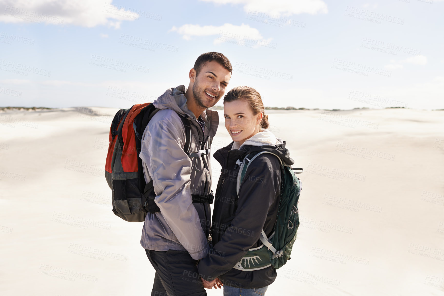 Buy stock photo Hiking, sand dunes and couple in portrait for adventure, desert landscape and travel on holiday. Holding hands, explorers and happy nomad people in Sahara terrain, outdoor or dry climate for love