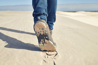 Buy stock photo Shot of a young male hiker walking along the sand dunes