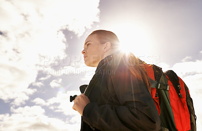 Buy stock photo Woman, hiking and walking by blue sky for fitness adventure in nature and extreme sport in hot sunlight. Athlete, below and survival gear for environmental exploration, travel and trekking in oman