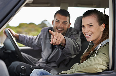 Buy stock photo Couple, car and pointing on roadtrip with travel for adventure, vacation or sightseeing with happiness in countryside. Woman, man or driving in vehicle for holiday journey, tourism and honeymoon trip