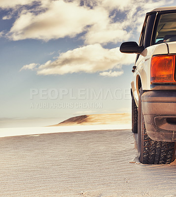 Buy stock photo Shot of a heavy duty 4x4 driving along some sand dunes