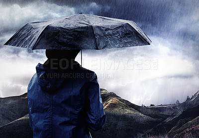 Buy stock photo Shot of a woman covered with an umbrella watching a thunderstorm over a mountain
