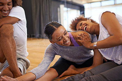 Buy stock photo Shot of three happy young women dancers stretching on the floor