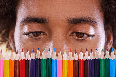 Buy stock photo Cropped view of an african man looking closely at a row of colorful pencil crayons