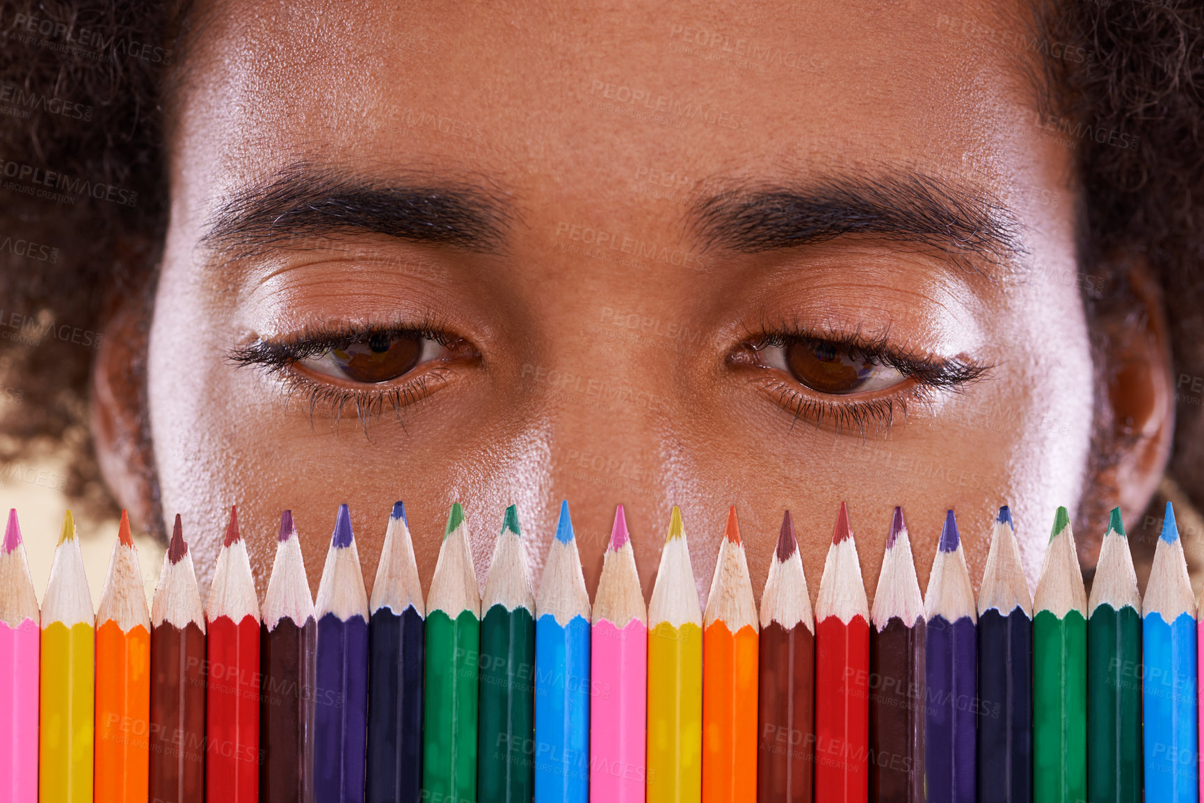 Buy stock photo Cropped view of an african man looking closely at a row of colorful pencil crayons