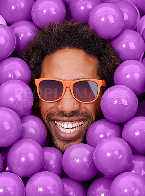Buy stock photo A young black man's face amongst purple pit balls