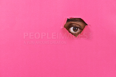 Buy stock photo A view of a man's eye looking through a hole in some colorful paper