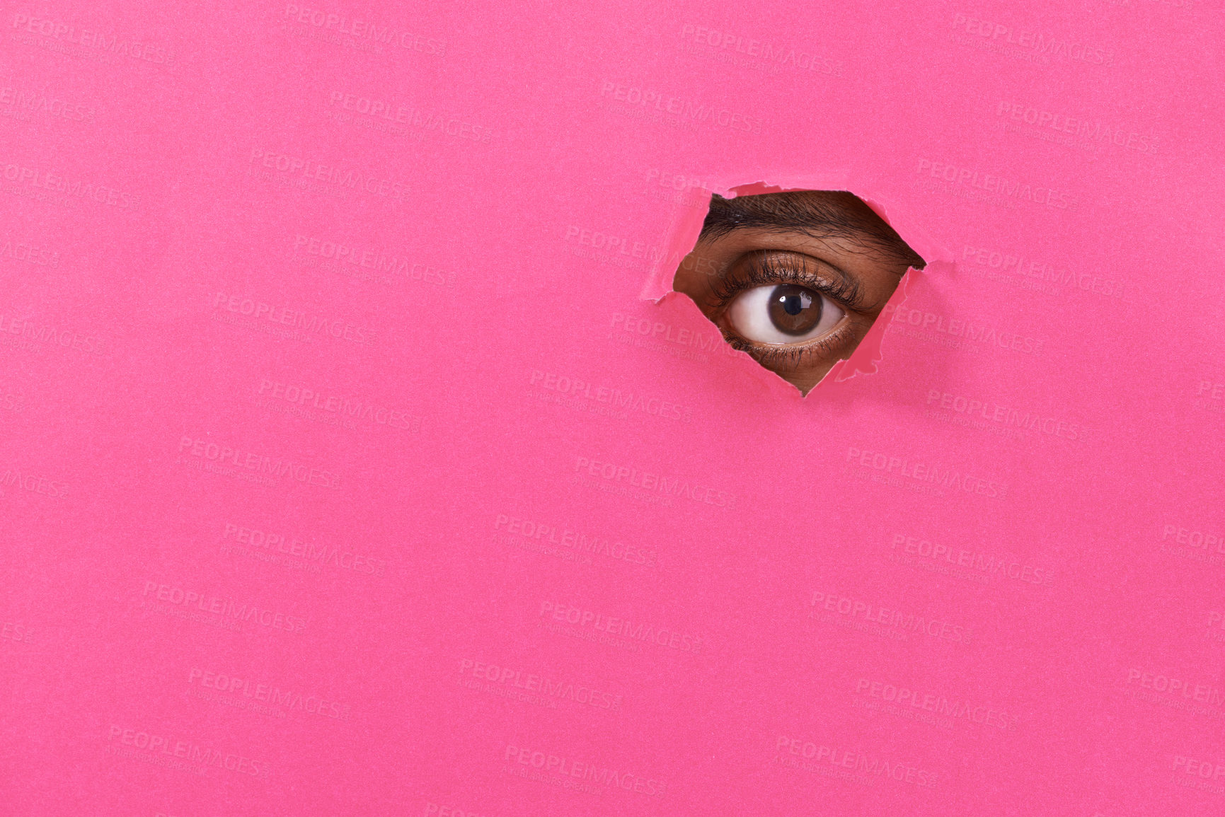 Buy stock photo A view of a man's eye looking through a hole in some colorful paper