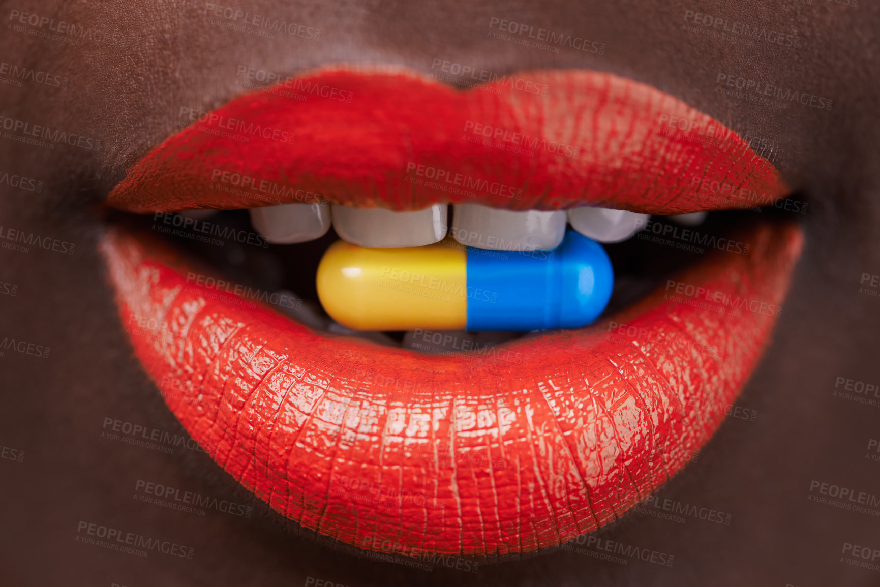 Buy stock photo Cropped view of an african woman with bright red lips with a capsule in her mouth