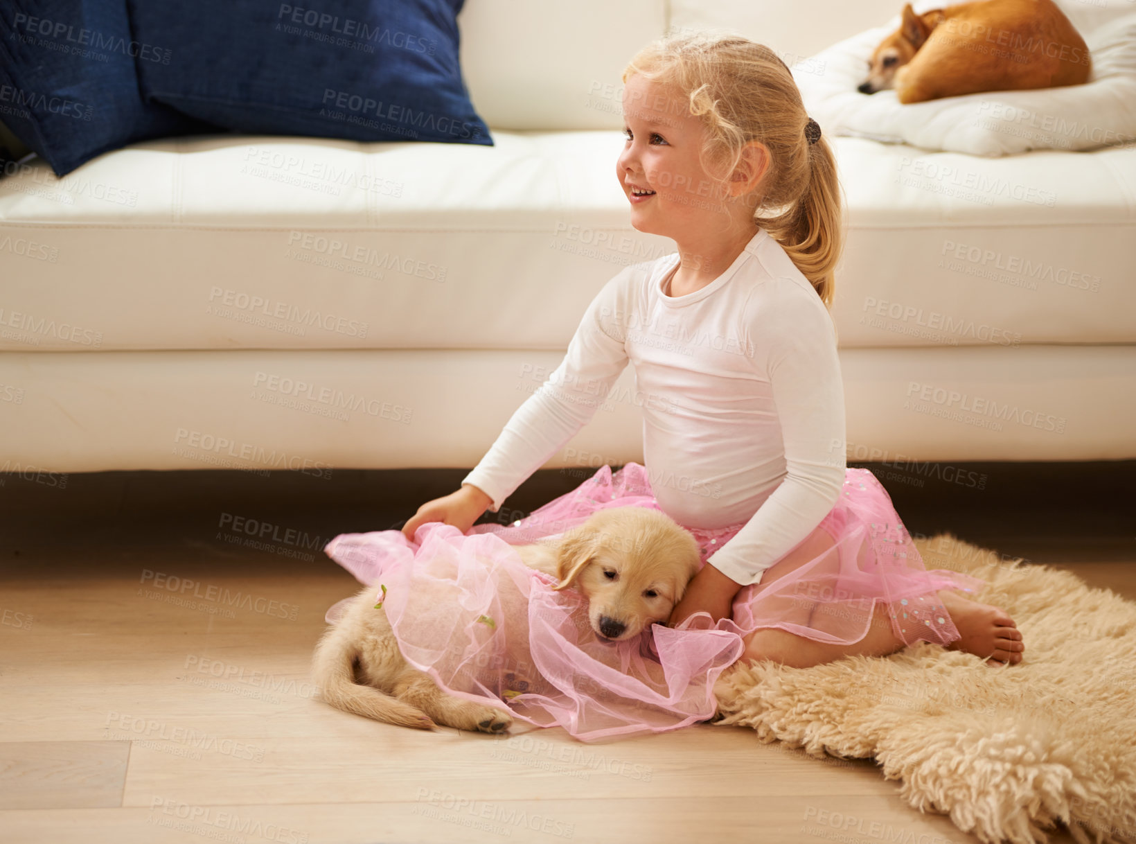Buy stock photo Shot of a little girl in a tutu playing with a puppy