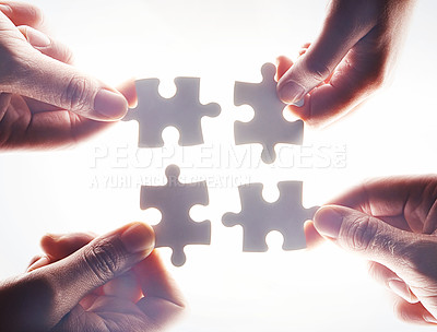 Buy stock photo Hands, puzzle and flare with a business team working together on project planning closeup from below. Teamwork, collaboration or synergy and employee group with a jigsaw for strategy or innovation