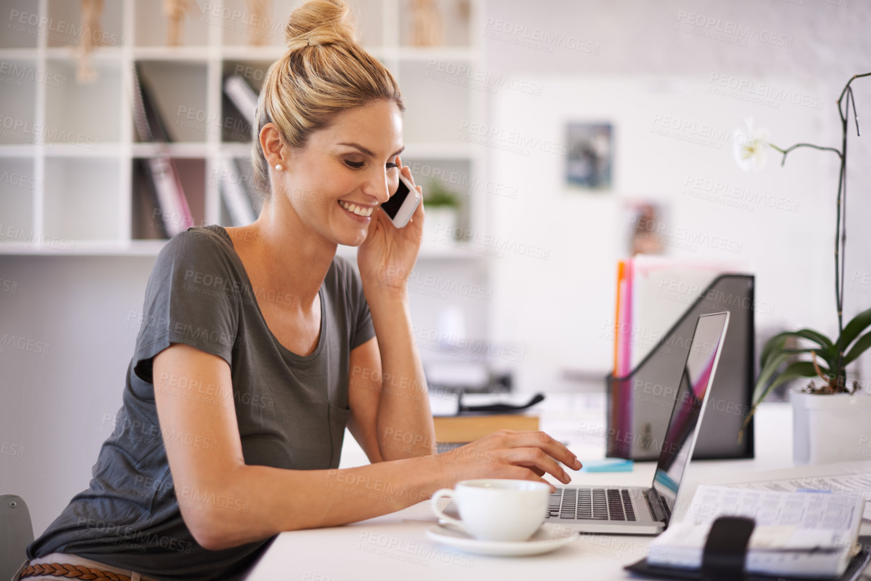 Buy stock photo A beautiful young businesswoman speaking on the phone while working on her laptop