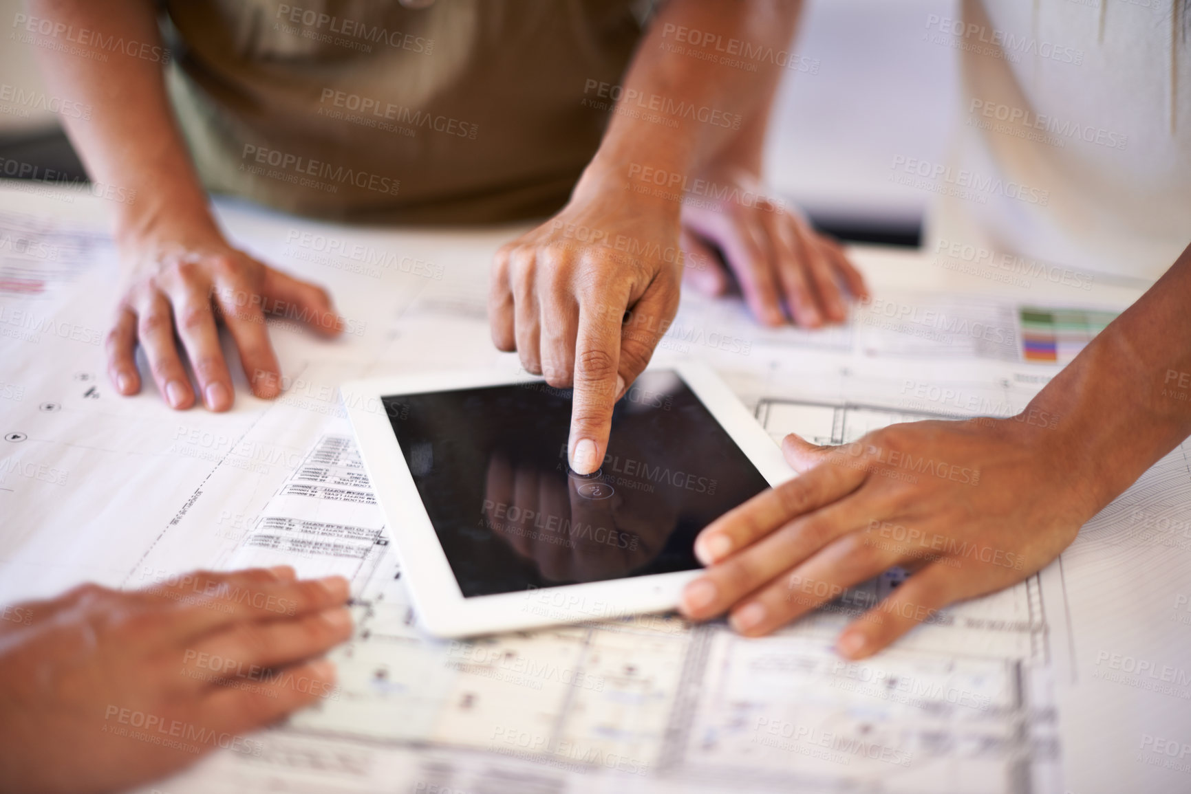 Buy stock photo Cropped shot of a group of designers using a digital tablet