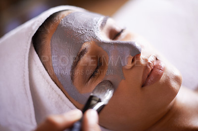 Buy stock photo Shot of a young woman enjoying a facial treatment at a spa