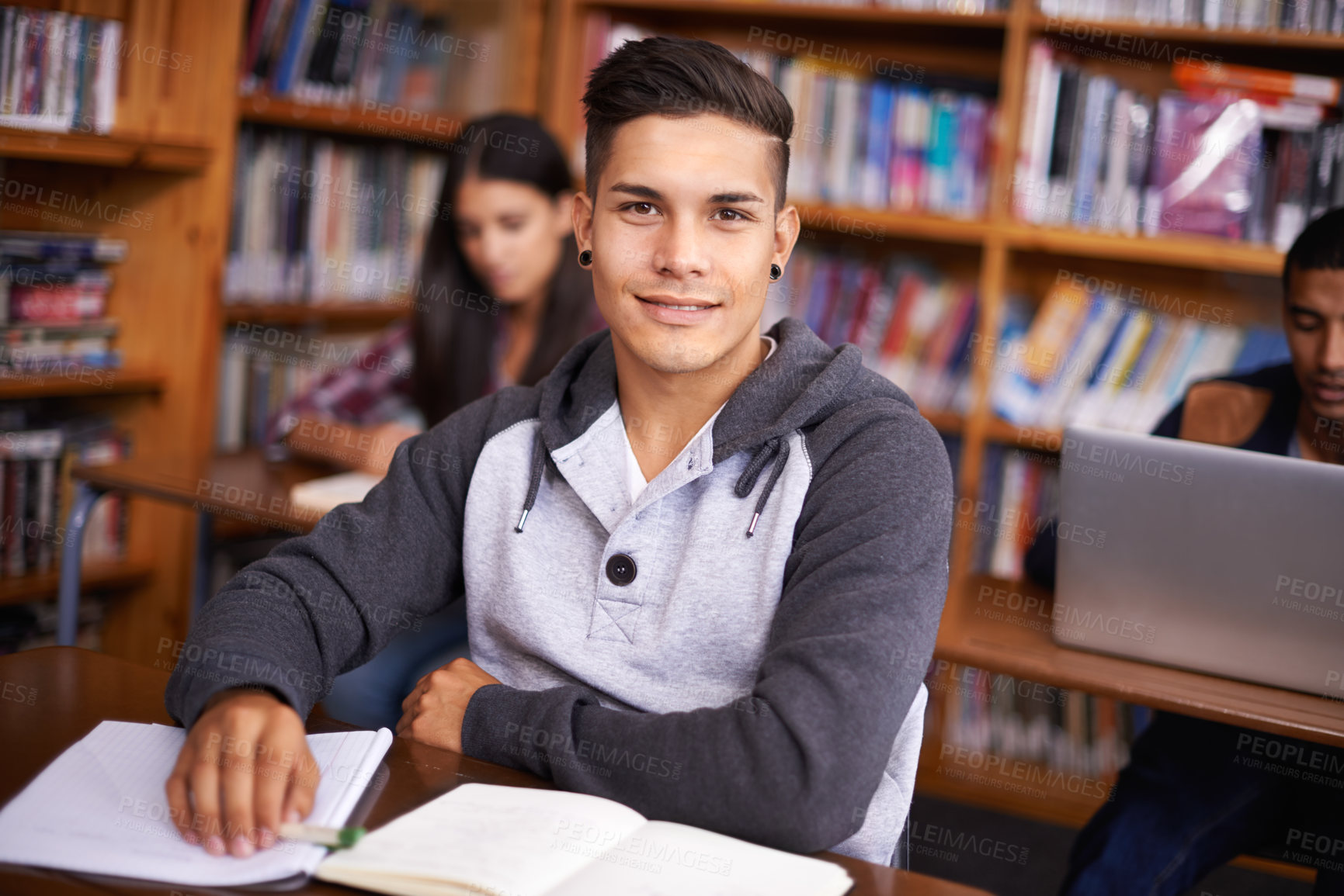 Buy stock photo Young man, portrait  or studying in library for test or scholarship on campus for class assignment. University student, face or happy for education or research in books for exam preparation by desk