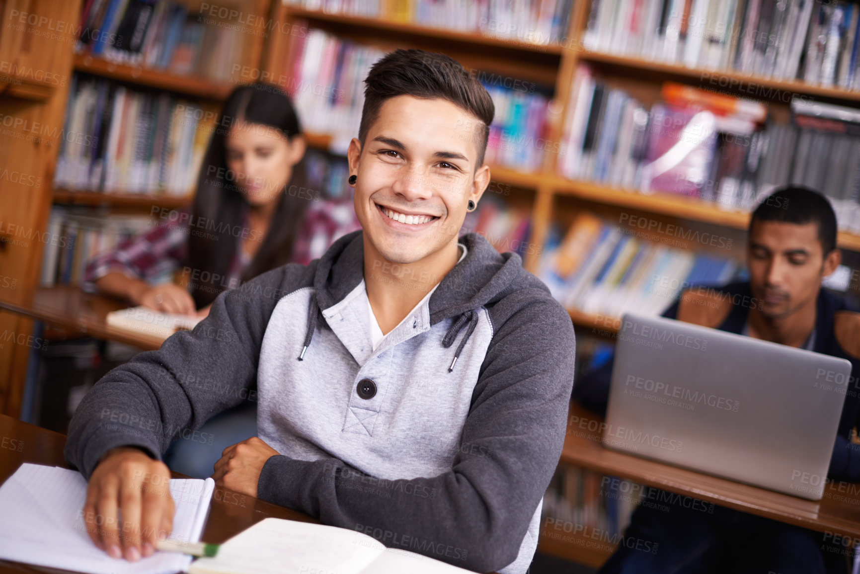 Buy stock photo Young man, portrait and studying in library for exam and education on campus for class assignment. University student, face and happy for scholarship or book research and tech for academic project