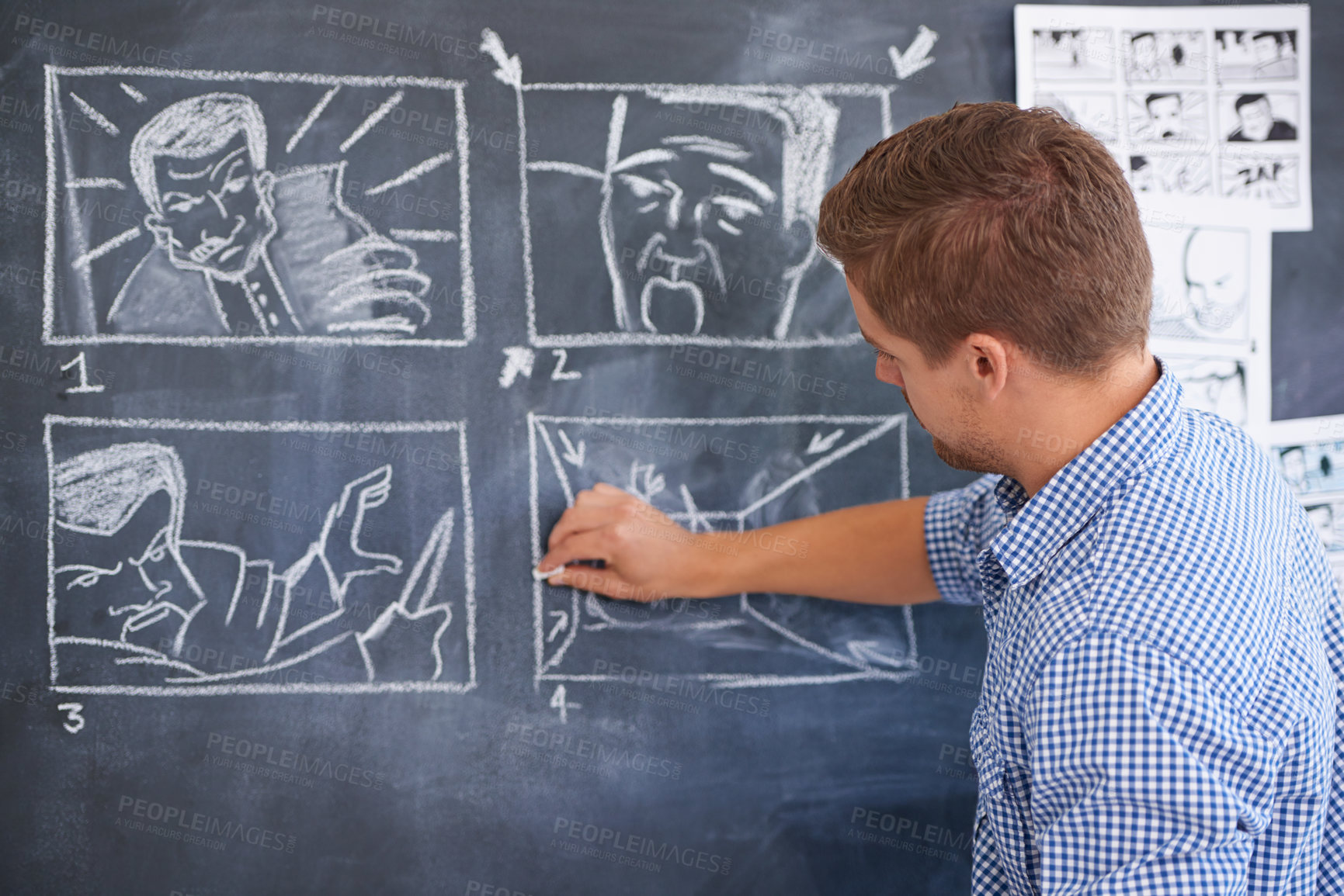 Buy stock photo A young man drawing up a storyboard on his office chalkboard