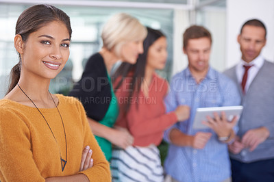 Buy stock photo A portrait of a happy businesswoman standing in an office with her coworkers in the background