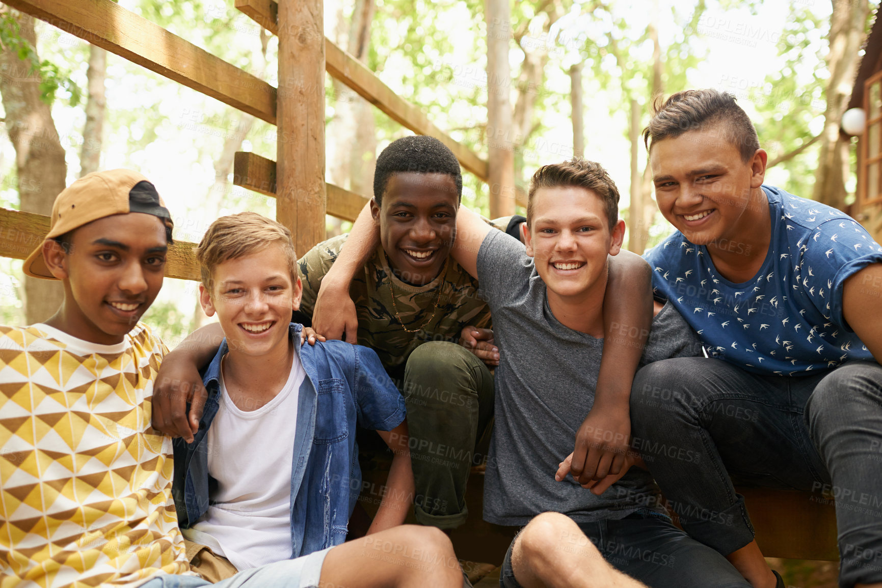 Buy stock photo Shot of a group of teen boys hanging out together outside