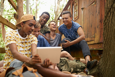 Buy stock photo Laughing, tablet and group of boy friends networking on social media, app or internet website. Happy, teenagers and young people scroll, research and browsing on digital technology on holiday.