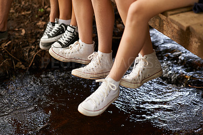 Buy stock photo Friends, shoes and legs with sneakers in river on wood to relax or chill on camping and tired with break. Outdoor, closeup and feet to rest for leisure or holiday in forest for hike, together and fun