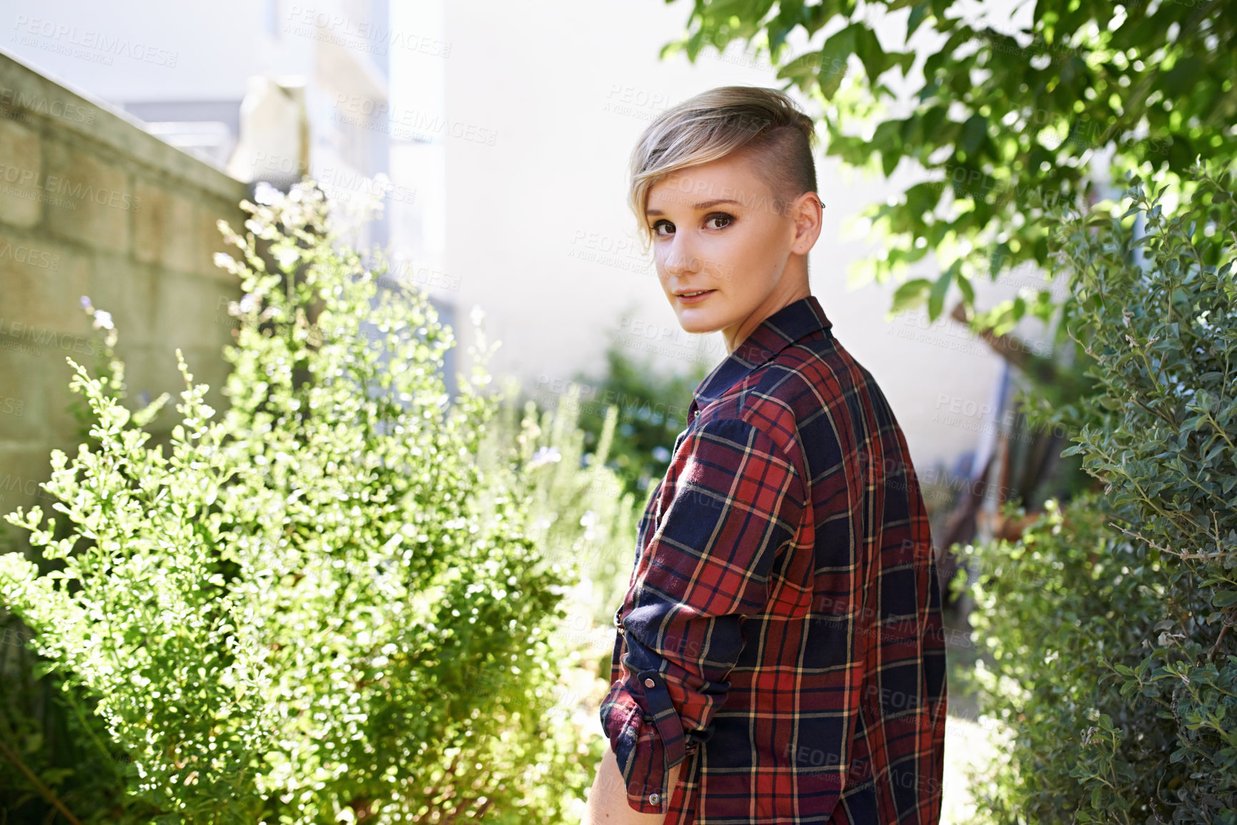 Buy stock photo A cropped portrait of a beautiful young woman standing in her garden