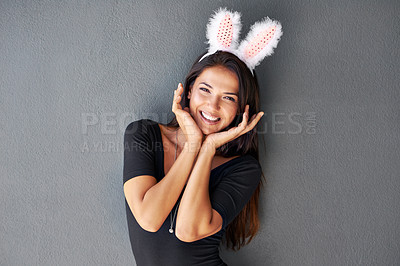 Buy stock photo Bunny ears, happy or portrait of woman with fashion isolated on wall or grey background with style. Funny joke, confident lady or casual female person in studio with pride, smile and trendy clothes