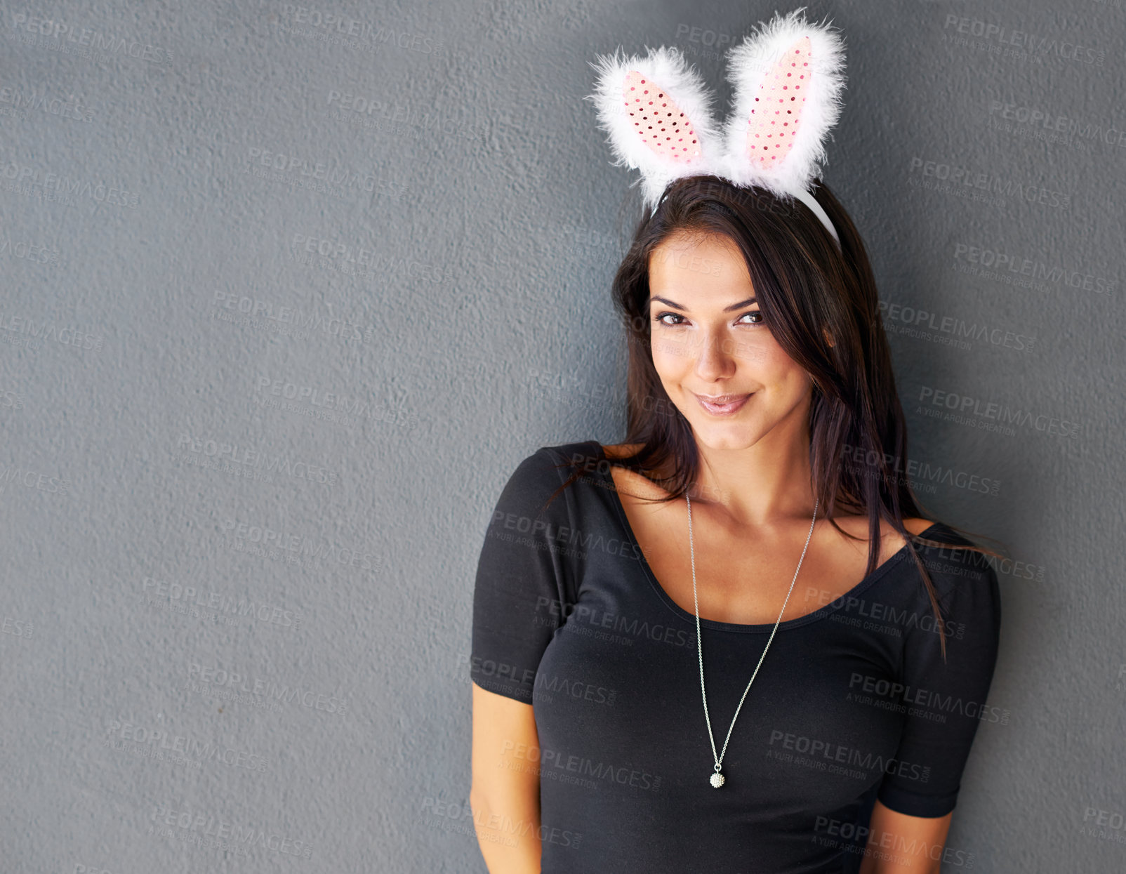 Buy stock photo Bunny ears, space or portrait of woman with fashion isolated on wall or grey background with style. Happy model, confident lady or casual female person in studio with smile, easter costume or mock up