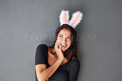 Buy stock photo Thinking, space or portrait of happy woman with bunny ears isolated on wall or grey background. Model laughing, confident or casual female person in studio with smile, funny joke or ideas on mock up