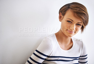 Buy stock photo A cropped portrait of a beautiful young woman standing against a white wall