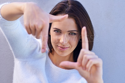 Buy stock photo Portrait, studio and woman with finger frame, smile and focus for creative fashion photography. Perspective, hand gesture and girl showing happy face, casual style and view finder on blue background.