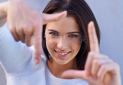Buy stock photo Portrait, smile and woman with finger frame, focus and studio for creative fashion photography. Perspective, hand gesture and girl showing happy face, casual style and view finder on blue background.