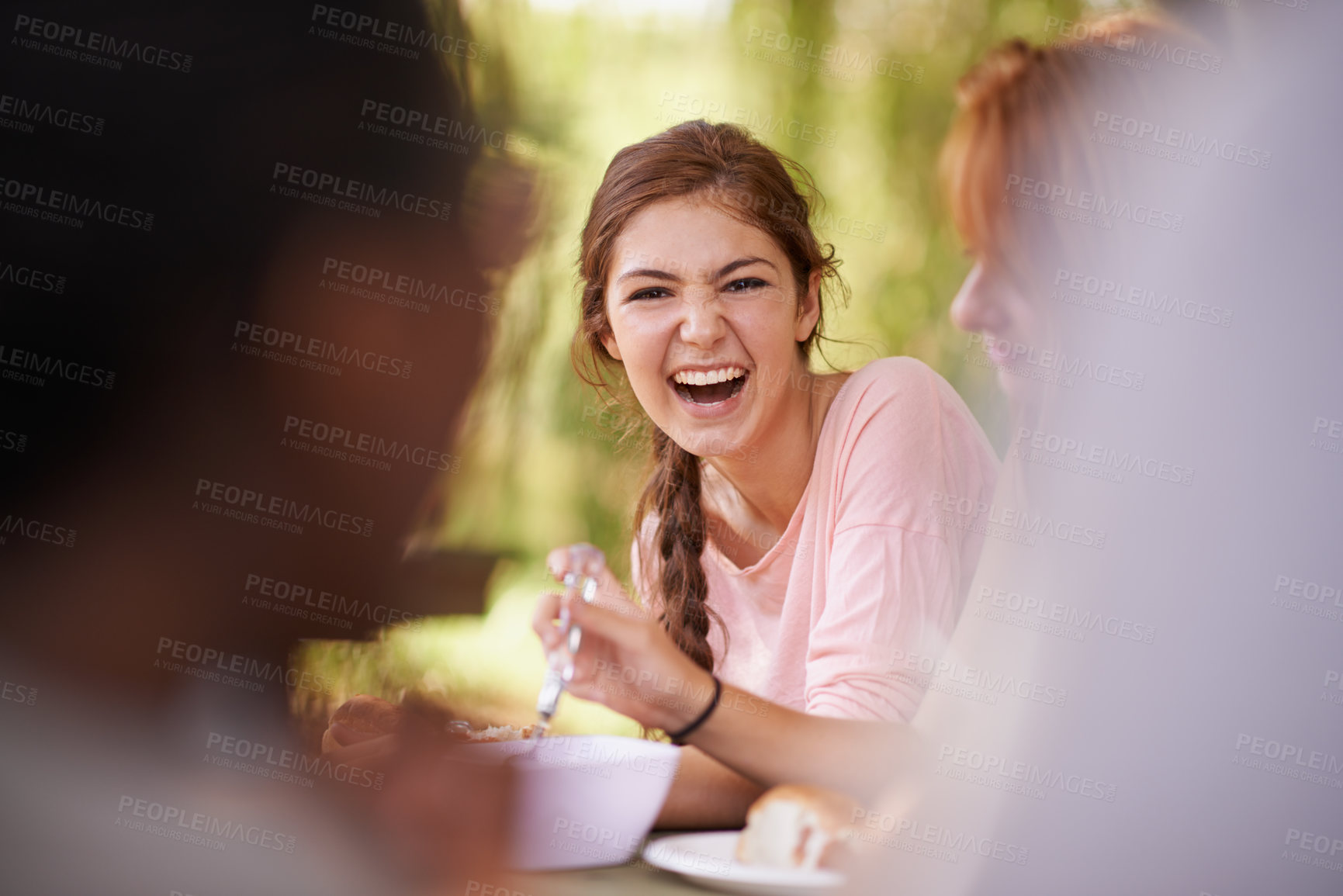 Buy stock photo Shot of teenage friends having a picnic at a table in the park