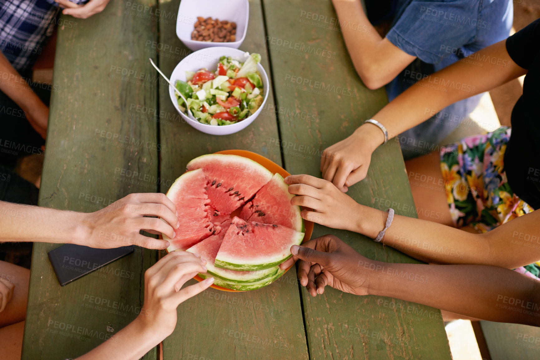 Buy stock photo Closeup, hands and group with watermelon, picnic table and nutrition with summer and weekend break. People, friends and outdoor with fruit and sunshine with vacation and bonding together with holiday