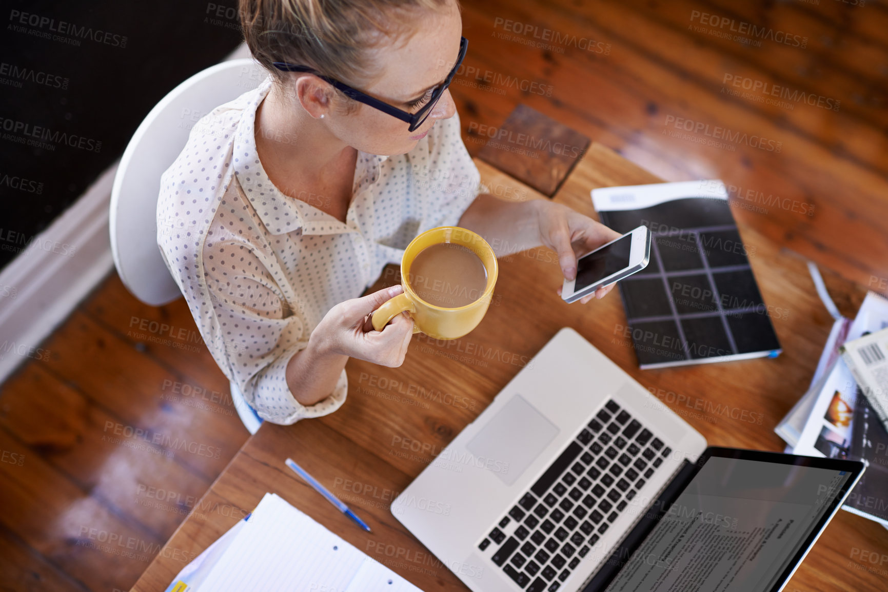 Buy stock photo High angle shot of a businesswoman drinking coffee while sitting at her desk