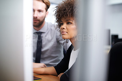 Buy stock photo Shot of a young woman  and her colleague working at a computer