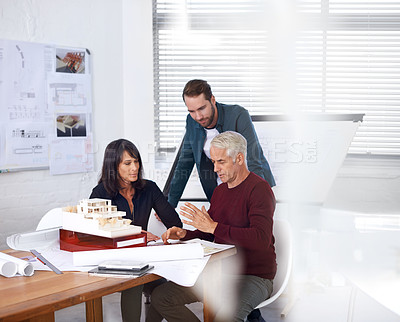 Buy stock photo Architects, teamwork and planning with building model, 3d design and development with colleagues. Remodeling, construction and pointing in meeting, contractor or property developer with lens flare