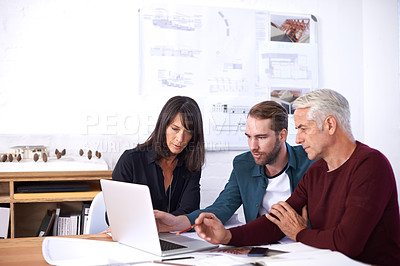 Buy stock photo Cropped shot of three architects working on a new building design