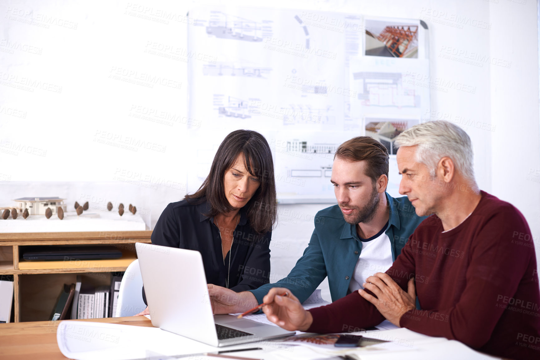 Buy stock photo Cropped shot of three architects working on a new building design