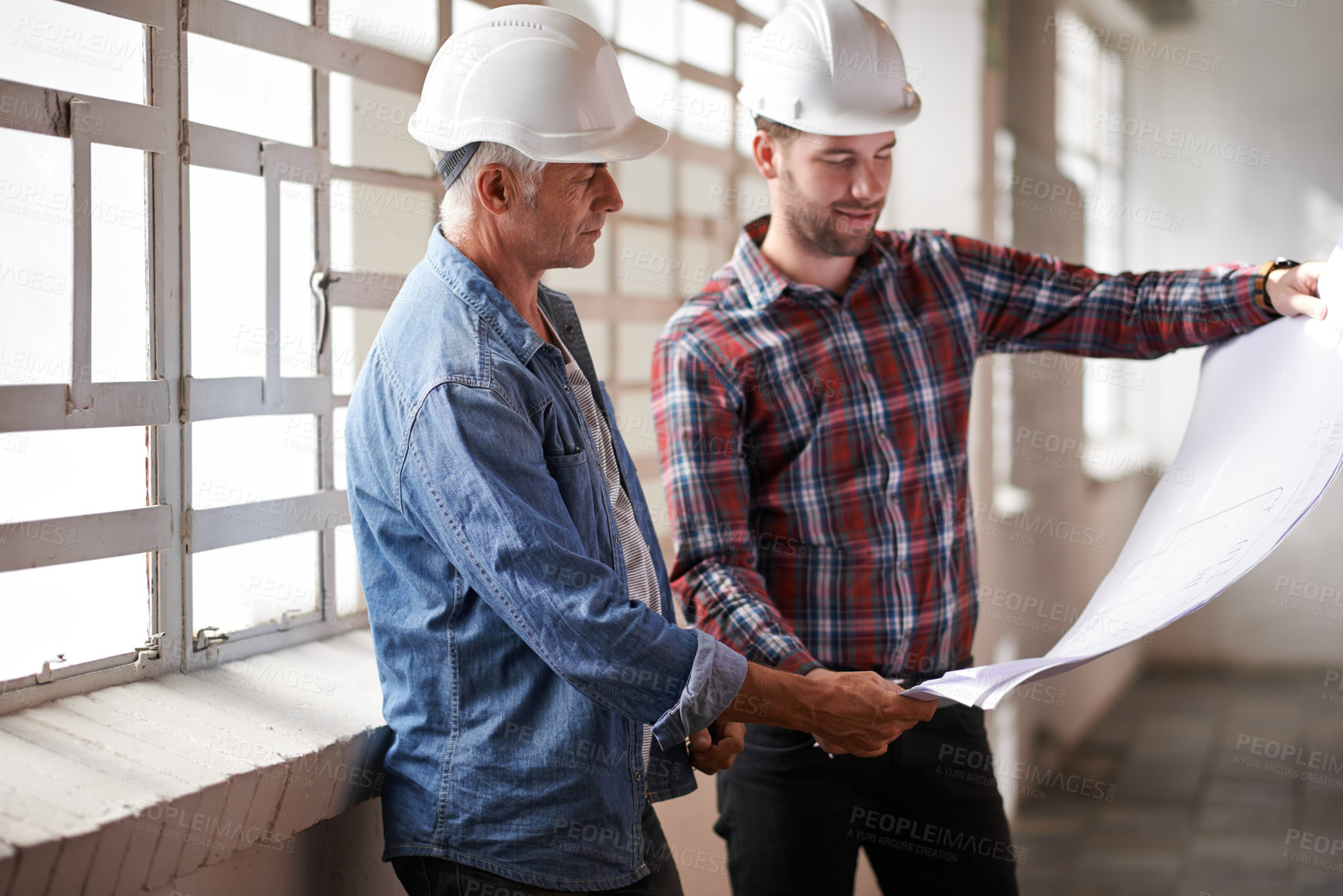 Buy stock photo Architecture team, blueprint and engineer reading for planning, analysis or real estate development. Men, paper and design at property, construction site or building with helmet, discussion or vision