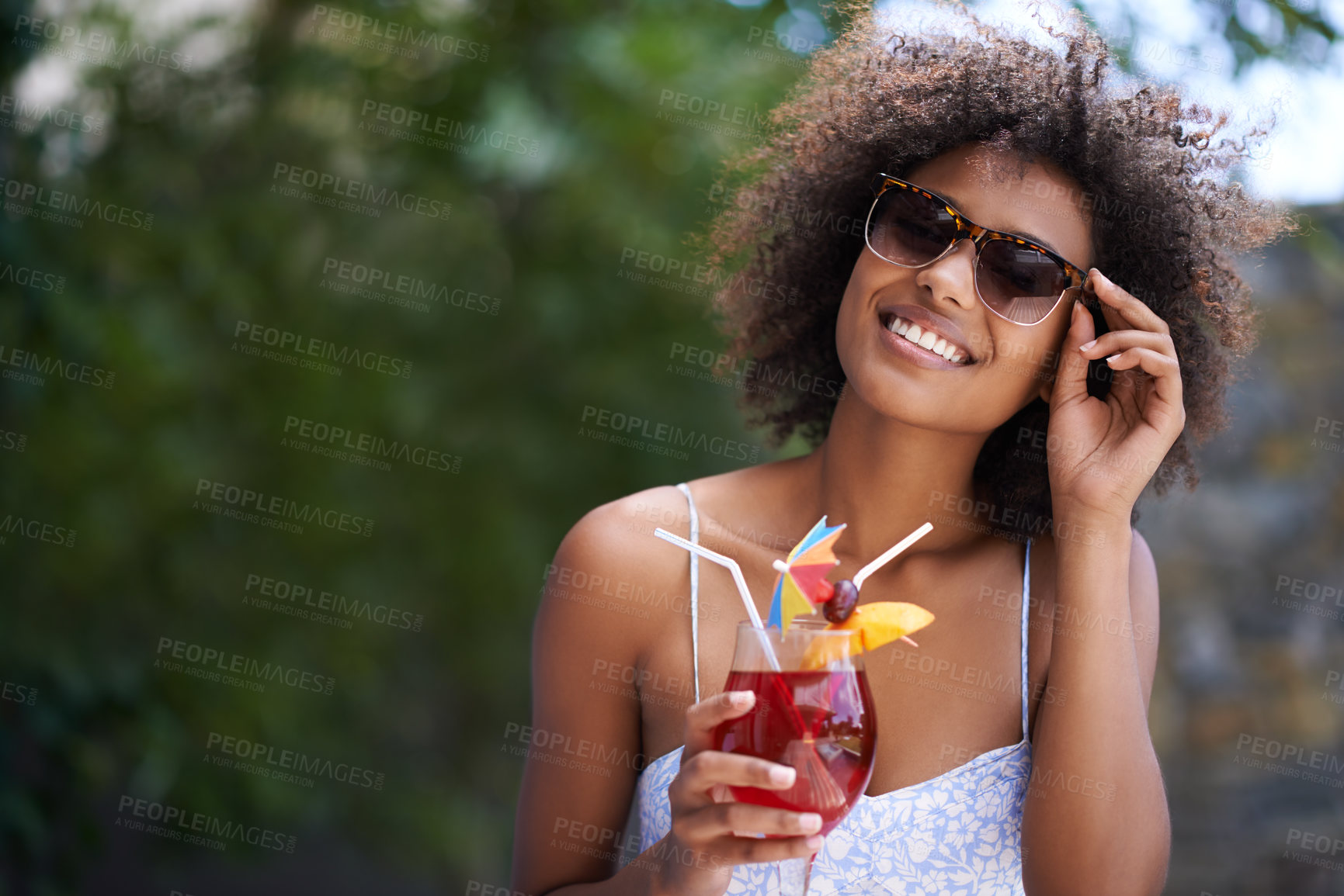 Buy stock photo Portrait of an attractive young woman wearing sunglasses enjoying a cocktail outside