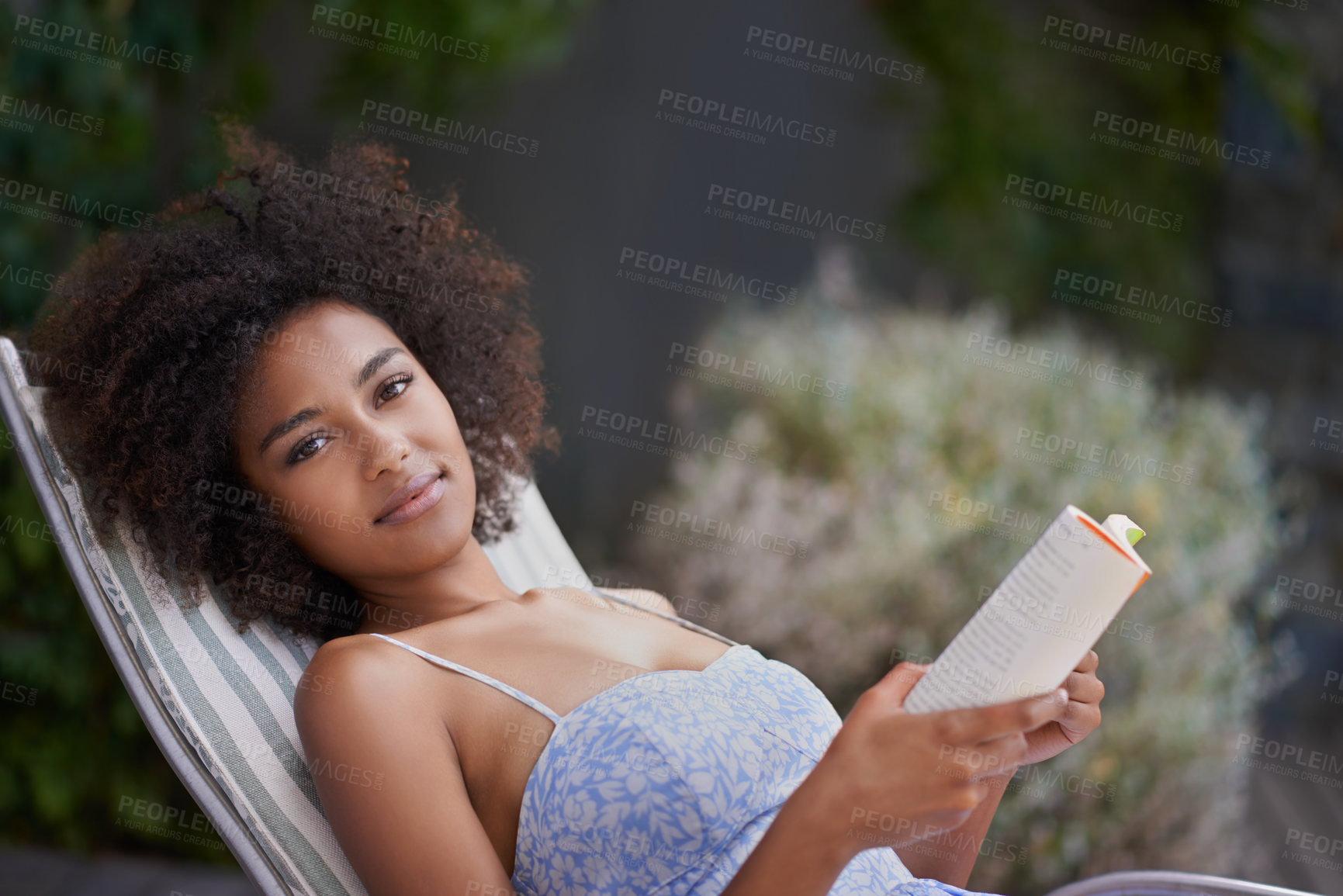 Buy stock photo African, woman and book at resort for relax, peace and chill on vacation. Happy, natural portrait of black female person reading in nature, retreat and on holiday for confidence in summer in dress