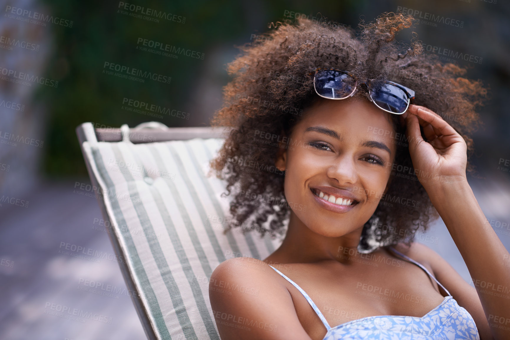 Buy stock photo African, woman and sunbathing and relax, holiday for summer on vacation and sunglasses for time fun. Happy, smile or female person laying on resort deck, comfortable or wellness patio furniture