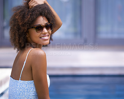 Buy stock photo Shot of an attractive ethnic woman posing in sunglasses by a pool