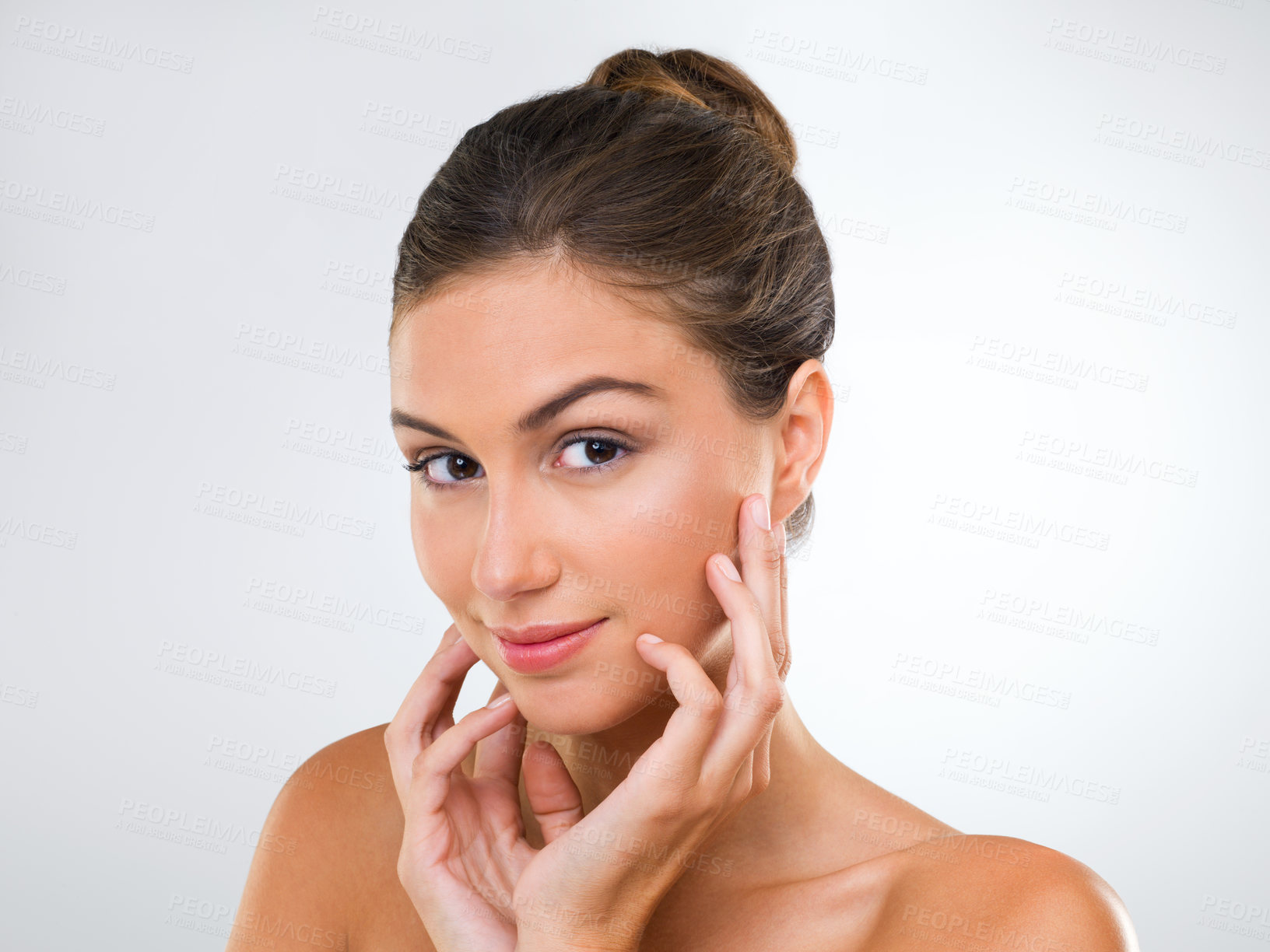 Buy stock photo Cropped studio shot of a beautiful young woman touching her face