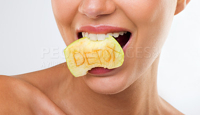 Buy stock photo A young woman biting an apple with the word 'detox' written on it