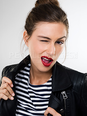 Buy stock photo Portrait of a beautiful young woman in a studio wearing a leather jacket winking