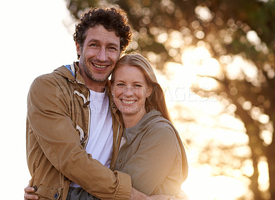 Buy stock photo Happy, couple hug and portrait in park, love and support with date for bonding and time together. Sunset, nature and people in forest for fresh air, loyalty and commitment with smile outdoor